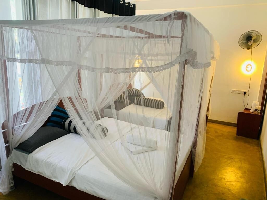 A bed with a white canopy and striped pillows.