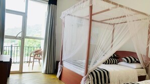Una cama con dosel, cabecera de madera y ropa de cama a rayas.