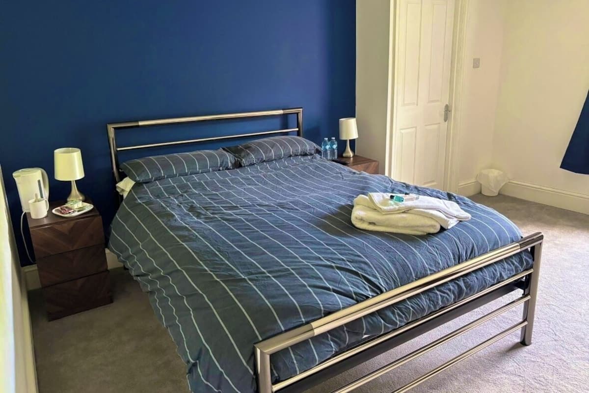 A bedroom with a bed, nightstands, and a door.