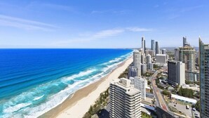 A coastal cityscape with high-rise buildings, a beach, and a clear blue sky. - Seabright Nook Resort Perks and Sky Views by the Sea (Surfers Paradise)