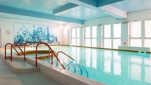 An indoor swimming pool with clear blue water, a metal ladder, and a mural on the wall. - THALACAP Ile de Ré (Ars-en-Ré)