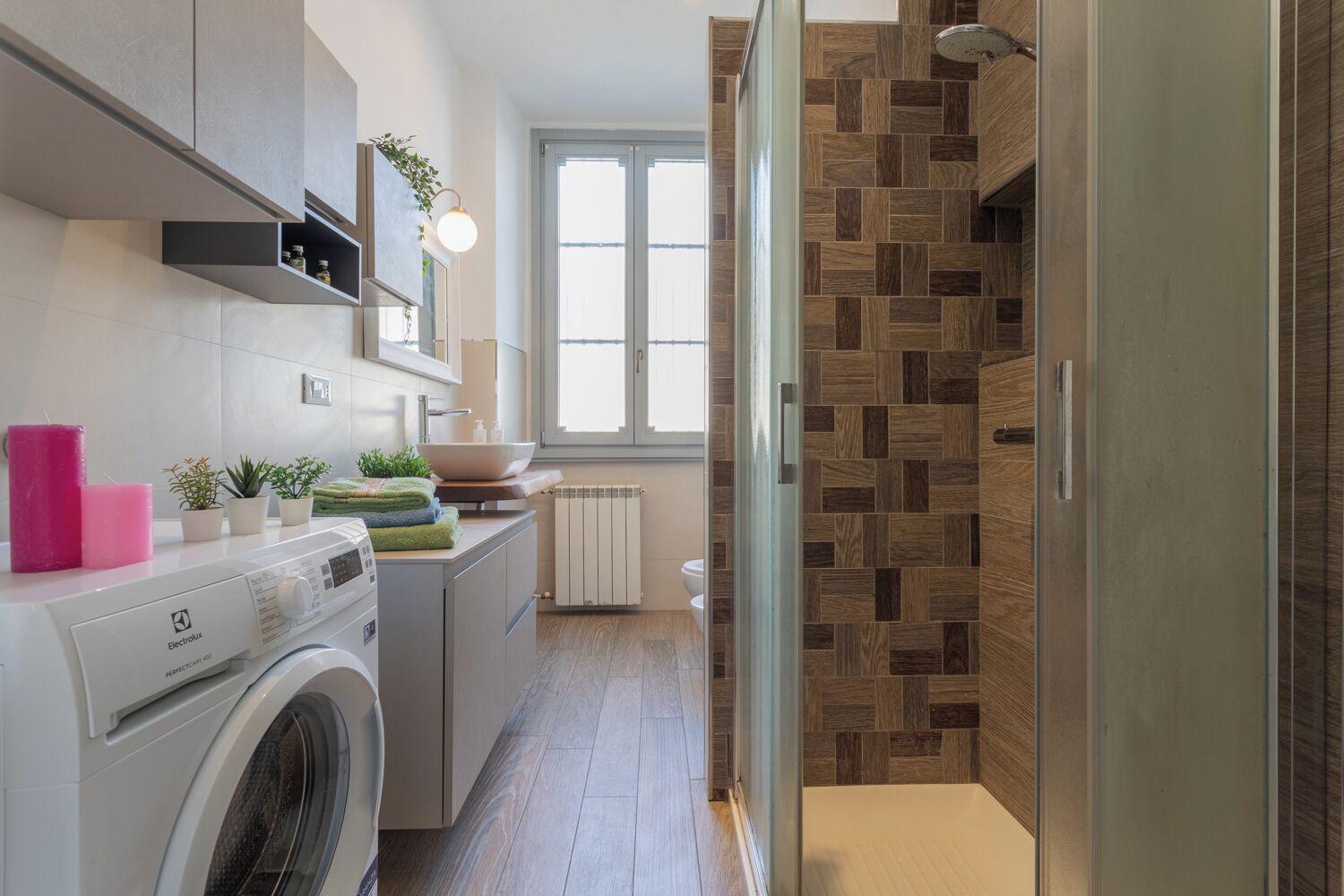 Een moderne keuken met een wasmachine, een spoelbak en een raam.