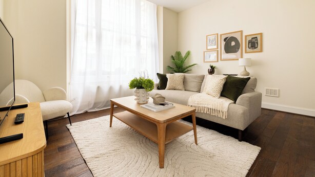 A living room with a sofa, coffee table, and a TV stand. - Notting Hill Ground-Floor Retreat (London)