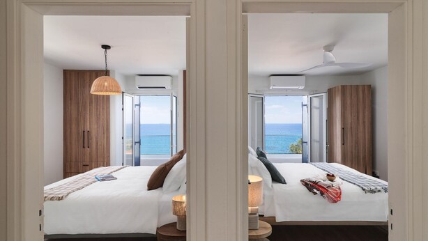 A hotel room with two beds, a view of the sea, and a balcony. - Villa Omega | Peaceful Coastal Stay with Sea Views (Polis)