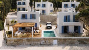 A modern villa with a swimming pool, multiple balconies, and a covered outdoor seating area. - Villa Omega | Peaceful Coastal Stay with Sea Views (Polis)