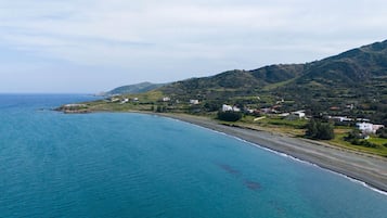 Un paisaje costero con playa, casas y colinas.