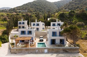A modern villa with multiple levels, a swimming pool, and a car parked in front. - Villa Astrofegia | Moonlit Escape with Sea Views (Polis)