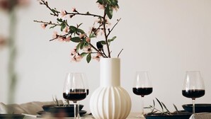 A dining table with a vase of flowers, two wine glasses, and plates. - Villa Paradise | Coastal Calm at Moonlight Villas (Polis)