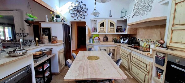 A kitchen with a central island, wooden cabinets, and various kitchen appliances.
