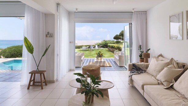 Un salon moderne donnant sur une piscine et un jardin.