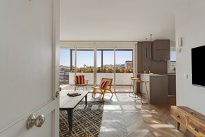A modern apartment with a balcony, a dining area, and a kitchen.