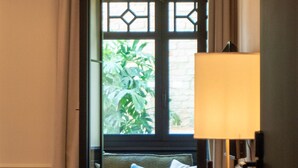A room with a sofa, a table with a lamp, and a bottle of wine. - Boada Riera (Terrassa)