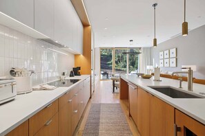 A modern kitchen with a central island, wooden cabinets, and a view to the outdoors.