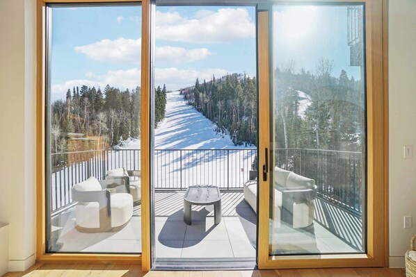A balcony with a view of a snowy landscape and a wooden deck.