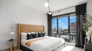 A modern hotel room with a large bed, city view, and a minimalist decor. - The first choice-vacation rental (Atlanta)