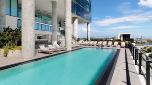 A rooftop pool with lounge chairs, a view of the city, and modern architecture. - Downtown Miami Getaway (Miami)