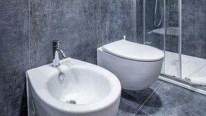 A modern bathroom with a bidet, a toilet, and a glass-enclosed shower. - YiD Leone X luxury 4 Bedroom (Florence)