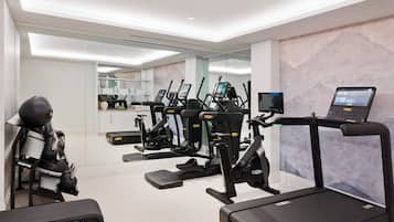 A modern gym with treadmills, elliptical machines, and a rowing machine.