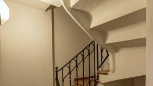 Un escalier avec une rampe en métal noir et des marches en bois.