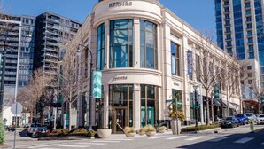 A modern building with a curved facade, large windows, and a prominent entrance. - A Cozy Luxurious Stay Buckhead Atlanta (Atlanta)