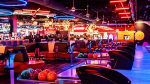 A bowling alley with multiple lanes, bowling balls, and a bar area in the background. - Modern LuxuryLoft In The Heart Of Atlantic Station (Atlanta)