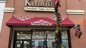 A storefront with a sign reading "Kilwin Chocolates, Fudge, Ice Cream" and a red awning with the text "Sweet in every Sense since 1947". - Modern LuxuryLoft In The Heart Of Atlantic Station (Atlanta)