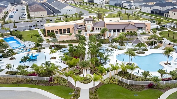 An aerial view of a residential area with a swimming pool, landscaped gardens, and modern houses.