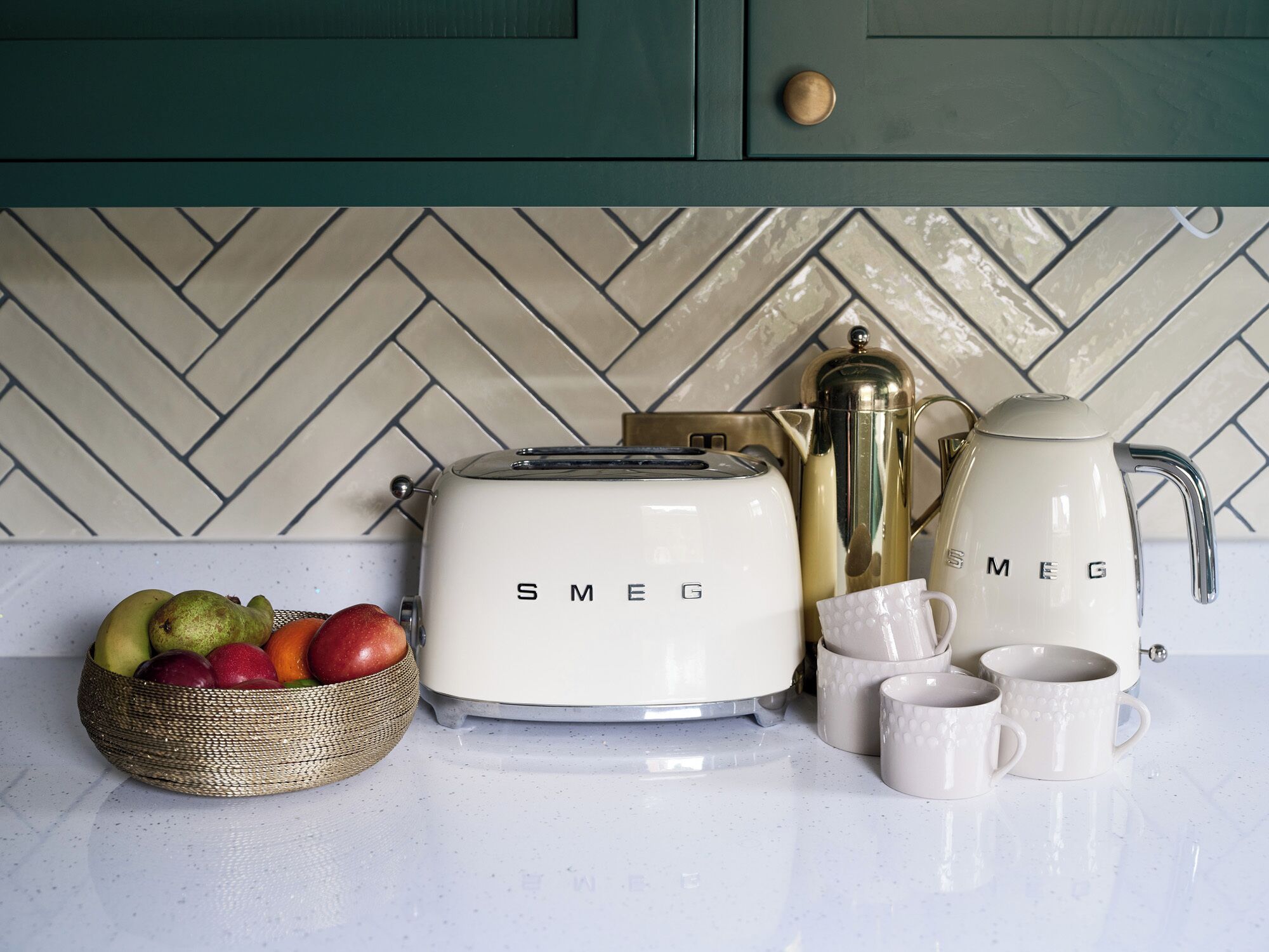 A kitchen counter with a toaster, a coffee maker, and a fruit bowl.