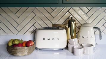 A kitchen counter with a toaster, a coffee maker, and a fruit bowl.
