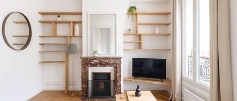 A modern living room with a fireplace, TV, and built-in shelves.