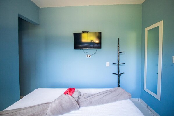 A room with a bed, a television mounted on the wall, and a coat rack. - Casa Noronha Martins (Fernando de Noronha)