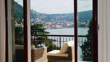 Un balcone con mobili in vimini che si affaccia su una città e un corpo d'acqua.