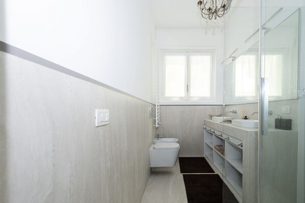 Een moderne badkamer met toilet, wastafel en spiegel.
