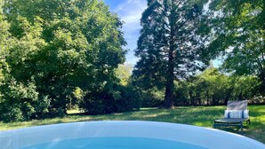 An outdoor swimming pool surrounded by trees.