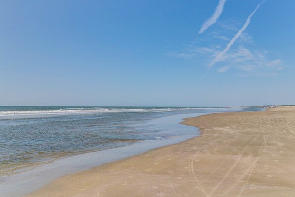 A beach with a clear sky and ocean waves.