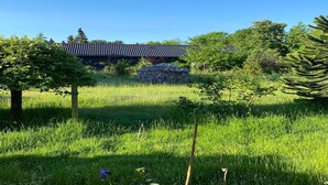 A traditional building with a tiled roof, surrounded by lush greenery and trees. - 5 Star Holiday Home in Hundested (Hundested)