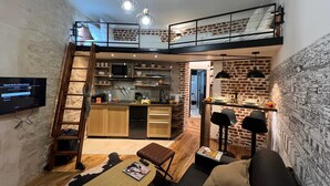 A loft-style living space with a kitchen, dining area, and a loft bedroom. - Rue de la Voûte - Mobility lease (París)