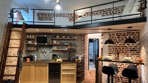 A modern loft-style apartment with a kitchen, dining area, and a loft bedroom. - Rue de la Voûte - Mobility lease (París)