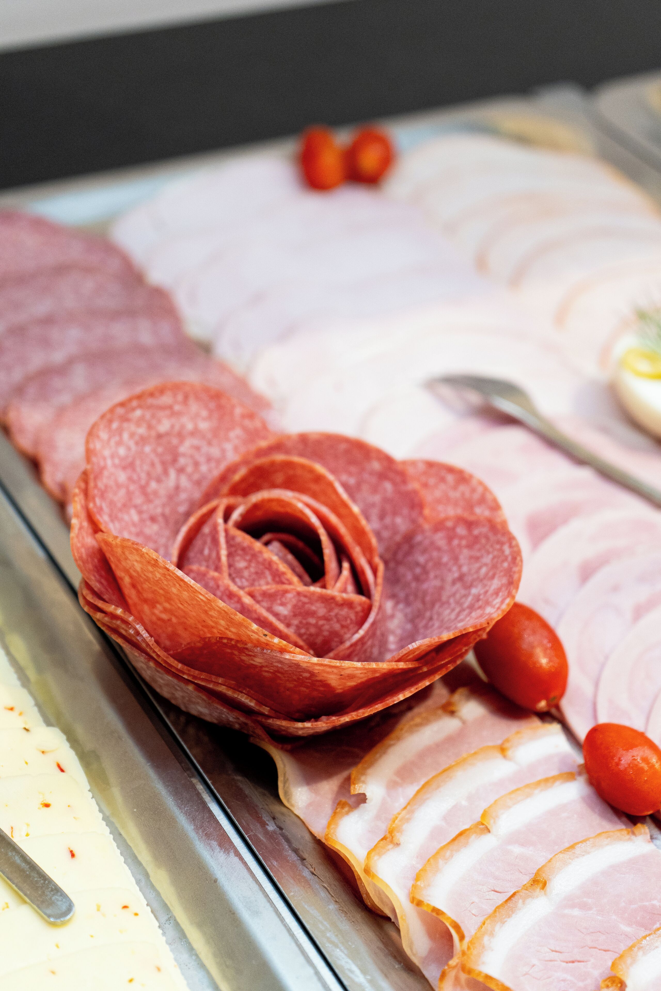 A meat platter with sliced ham and salami.