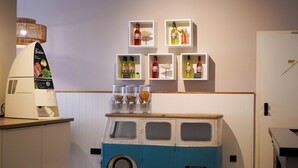 A kitchenette with a food processor, a blue and white van, and shelves with bottles and condiments. - Hotel Seebrise Grömitz (Groemitz)