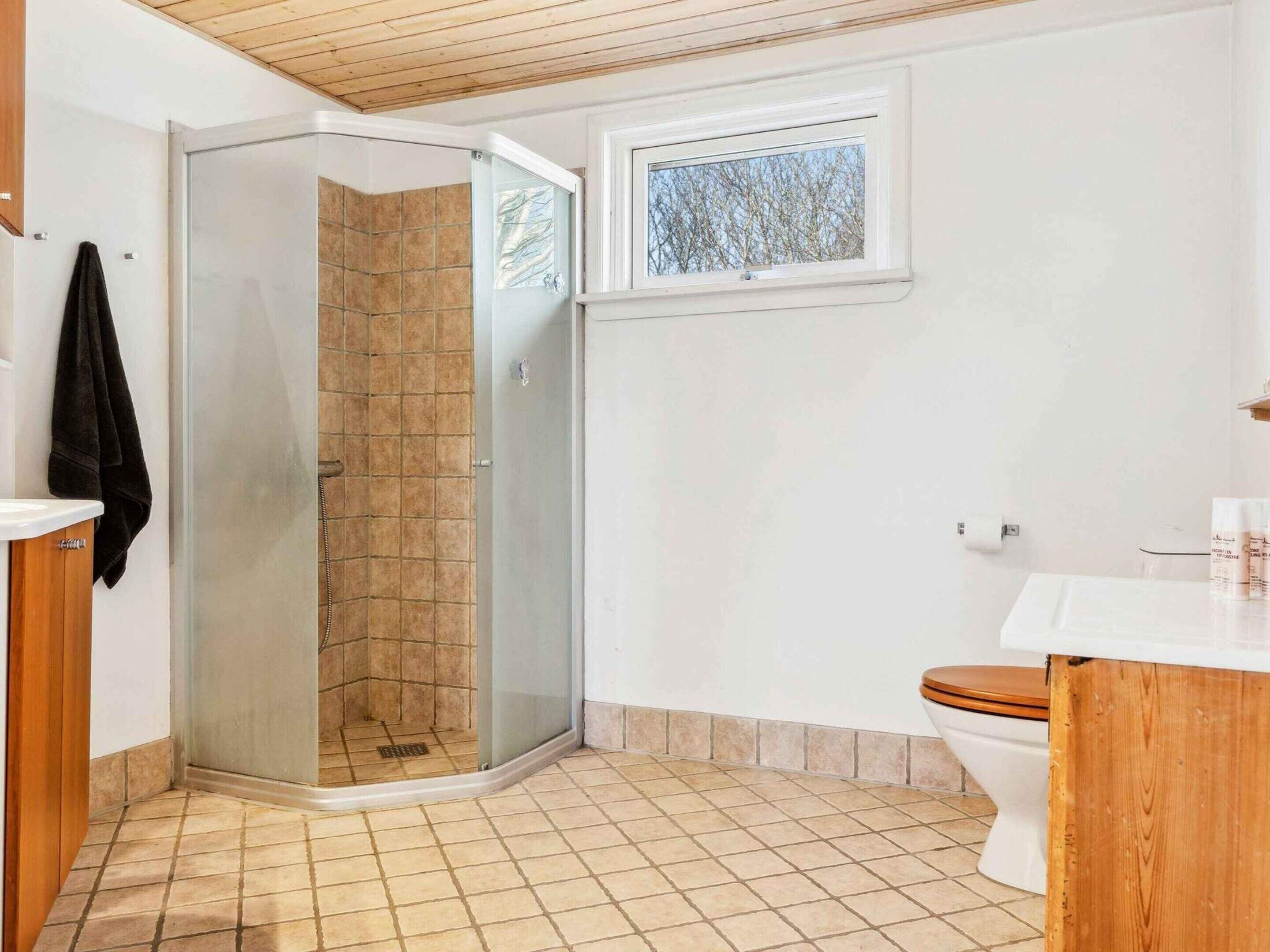 Een badkamer met een douchecabine, toilet en wastafel.