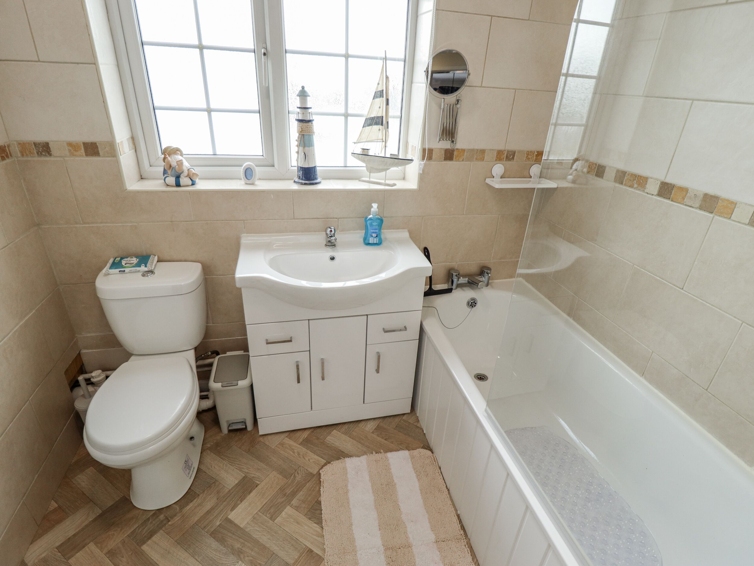 A bathroom with a toilet, sink, and bathtub.