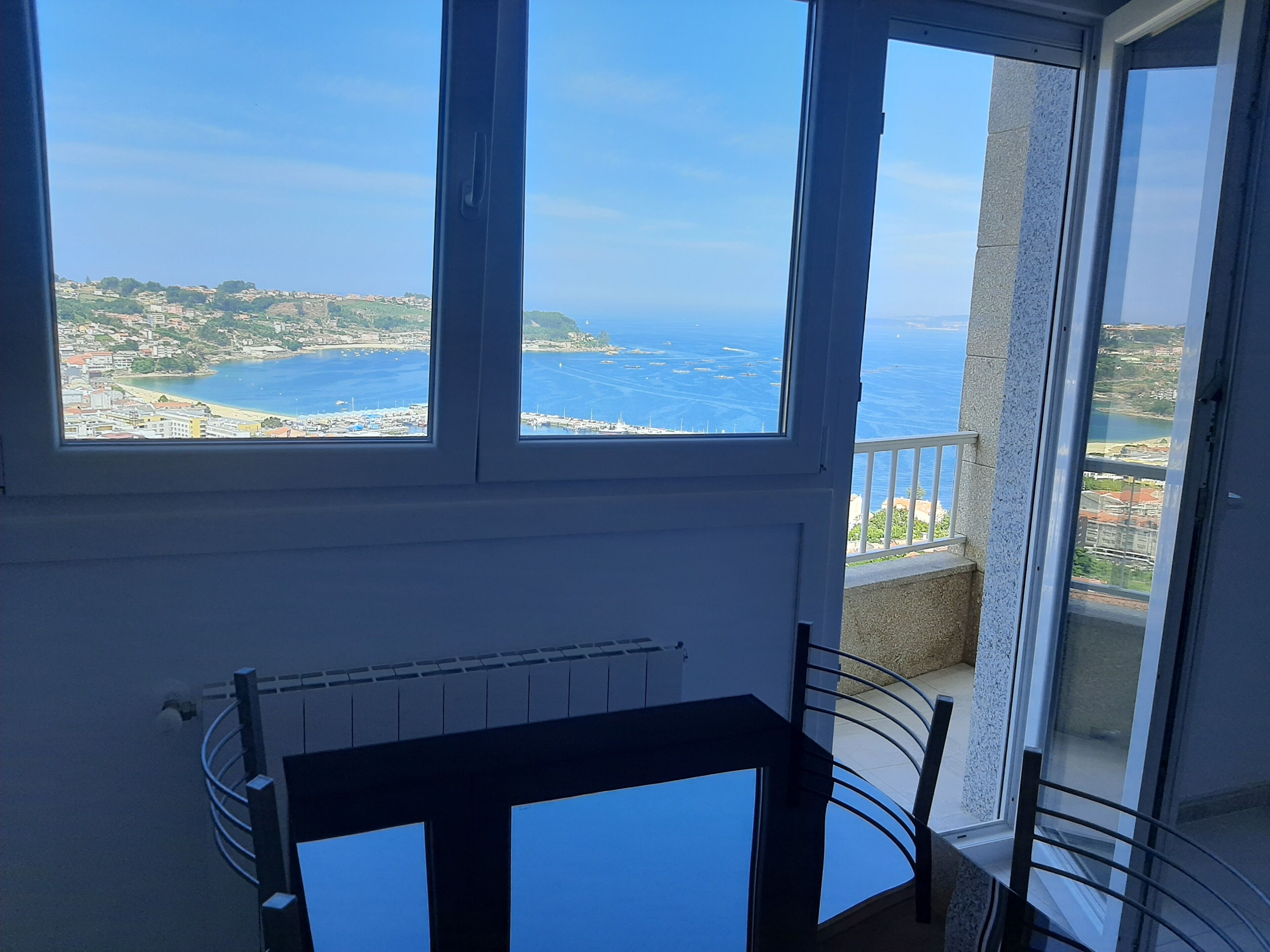 Ein Balkon mit Blick auf das Meer und eine Küstenstadt.