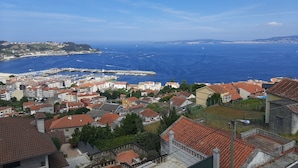 Eine Küstenstadt mit einem Hafenbecken, Reihenhäusern und Blick auf das Meer.