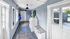 A hallway with a tiled floor, white doors, and a ceiling with a skylight. - 5 Star Holiday Home in Svaneke (Svaneke)