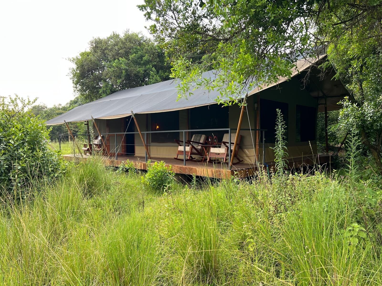 Alojamento isolado ao ar livre com terraço coberto, rodeado por vegetação exuberante.
