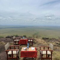Una mesa colocada sobre un saliente rocoso con una vista panorámica de un paisaje extenso.