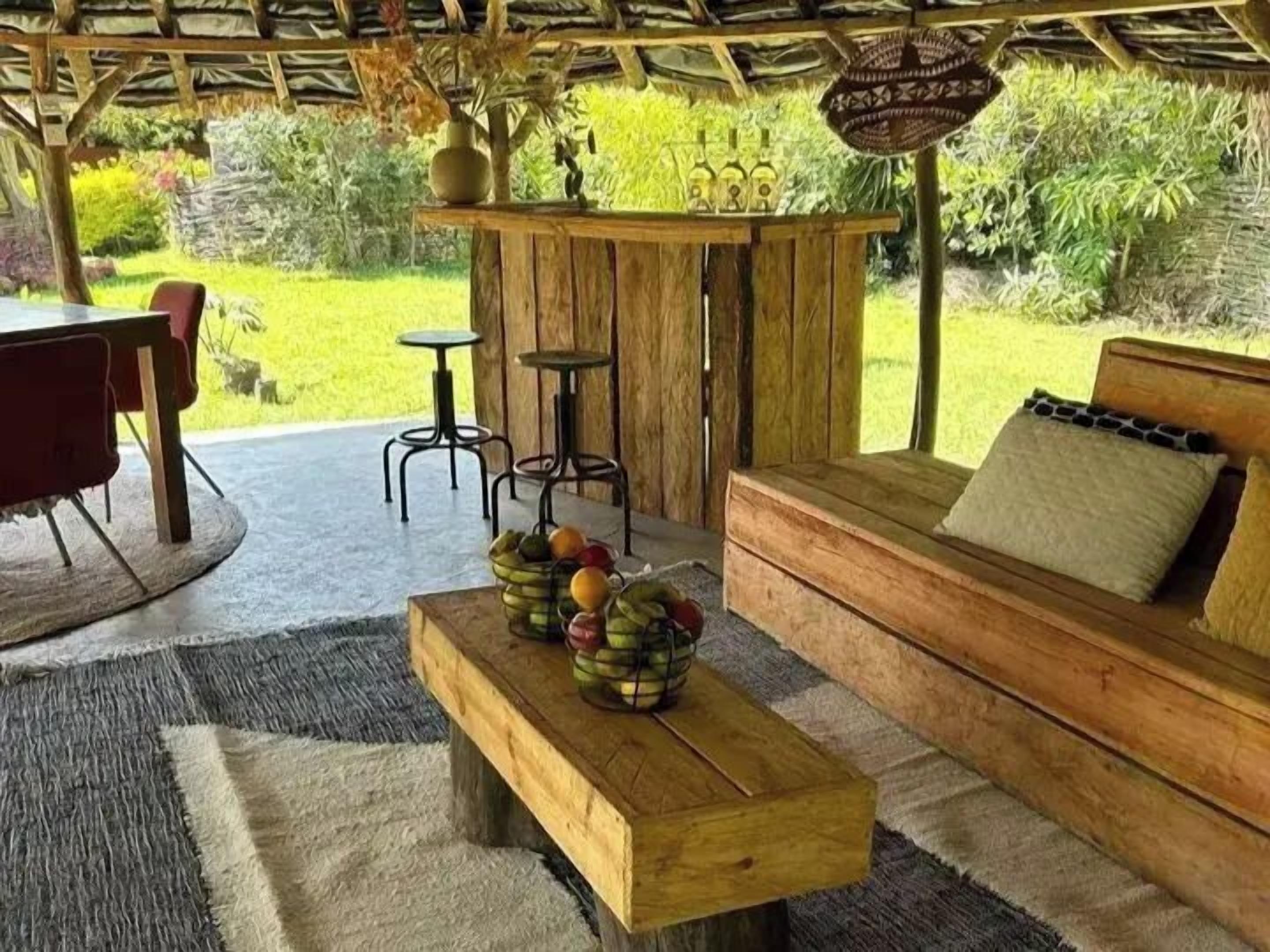 Een terras met een houten bank, een bank en een tafel met fruit.