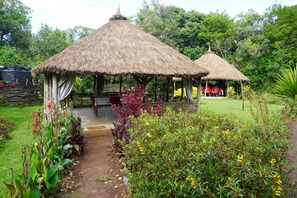 Two thatched-roof structures with seating and a pathway leading to them. - Oreteti Mara Lodge (Lolgorien)
