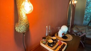 A wooden table with a light fixture, a mirror, and a tray with food and drinks.